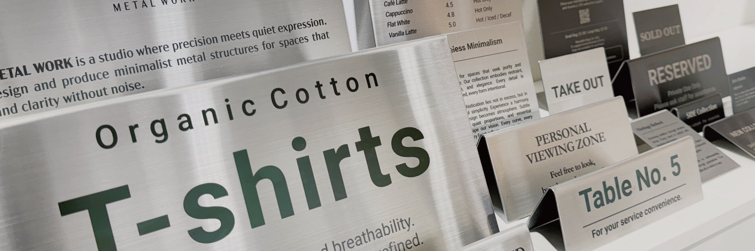 Stainless steel tabletop and table tent signs from the ECHO Collection displayed on a counter