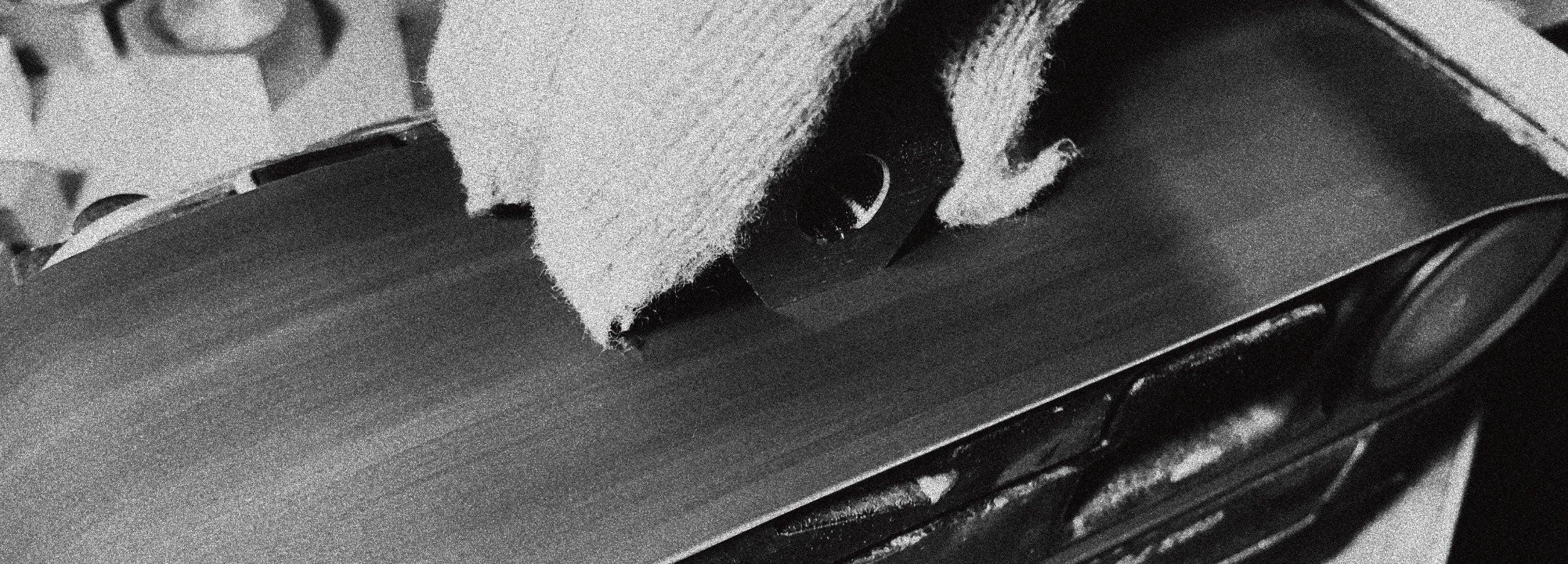 A detailed close-up of a brushed metal surface used by SAE METAL WORK, symbolizing the brand's founding in 2017 and its philosophy of mediating between spaces through material precision and texture.