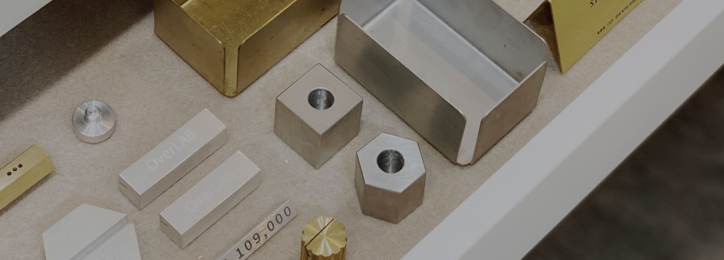 Array of custom metal branding objects in brass, aluminum, and stainless steel, symbolizing SAE METAL WORK’s identity and design philosophy.